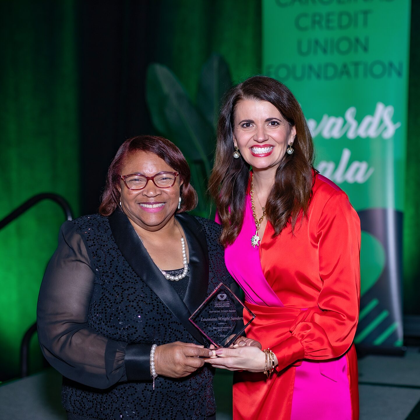 Louisiana Wright Sanders (left), member of the SRP Federal Credit Union Board of Directors, and Lauren Whaley, President/CEO of the Carolinas Credit Union Foundation, hold Wright Sanders's 2024 Advancing Equity Award together for a photo.