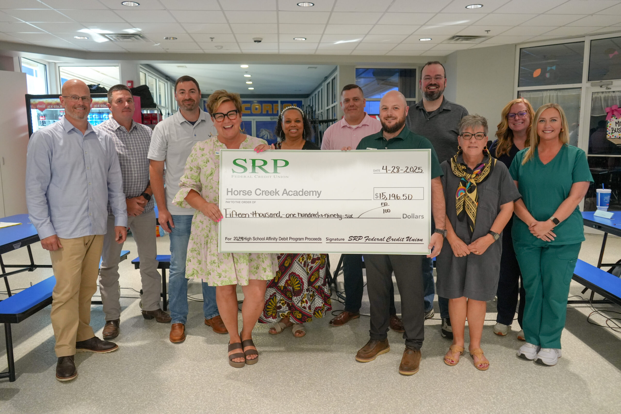 Dr. Ann Marie Taylor, Chief Vision Officer and Lead Learner of Horse Creek Academy, and Michael Clennett, SRP Community Engagement Specialist, present a check from 2024 SRP Affinity Debit Card Program proceeds alongside the HCA Board of Directors.
