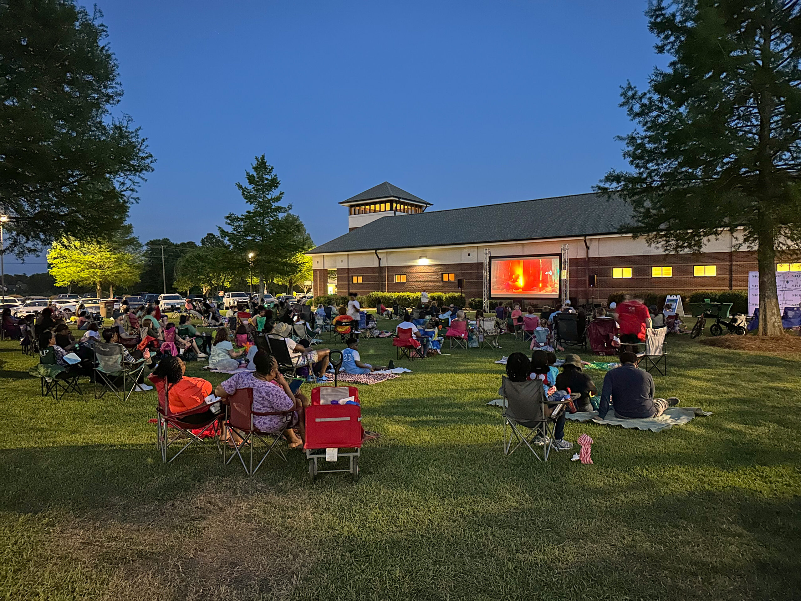 Members, families, and guests enjoy an outdoor movie showing at SRP Federal Credit Union's Administrative Campus. Pictured is a previous SRP Movie Night from Spring 2024.