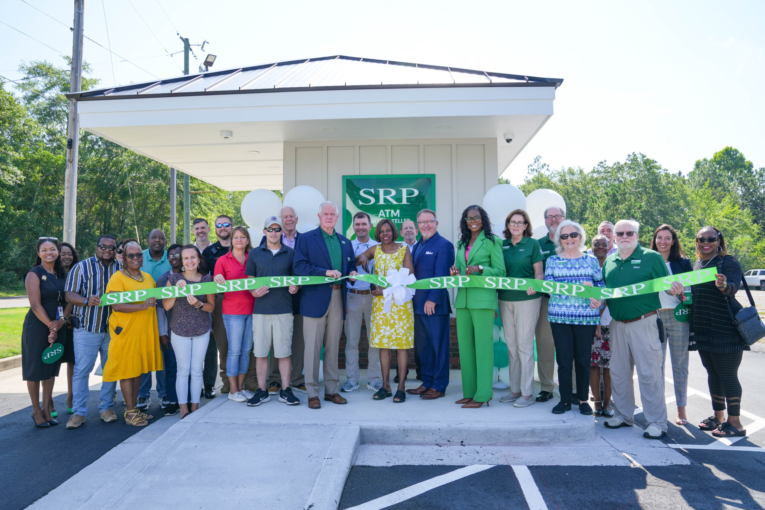 Representatives of SRP Federal Credit Union join community leaders, community members, and elected officials in a ribbon-cutting ceremony in front of a newly built Virtual Teller ATM in New Ellenton, South Carolina.