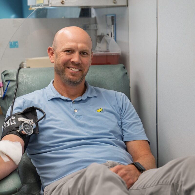 A man donates blood inside a mobile donation center.