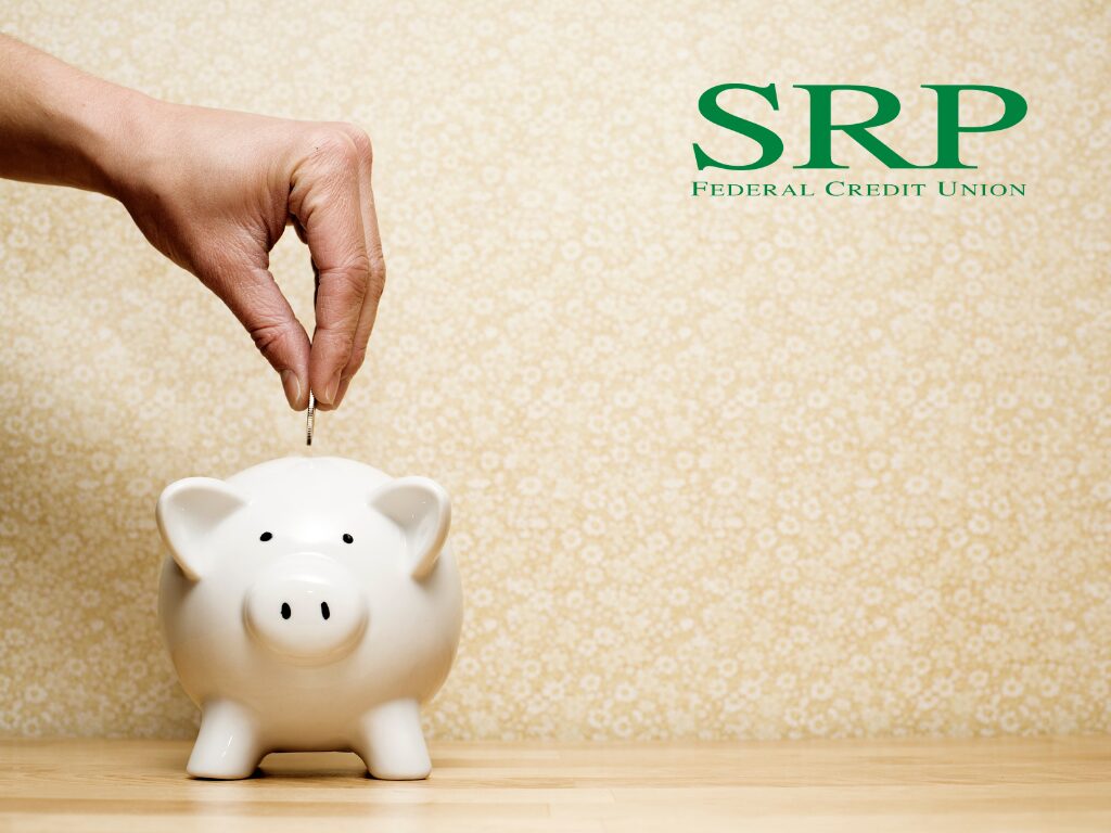 A hand drops a coin into a piggy bank, illustrating how the habit of saving can help you master your money.