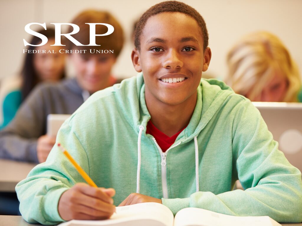 A high school student in a classroom with a notebook and a pencil