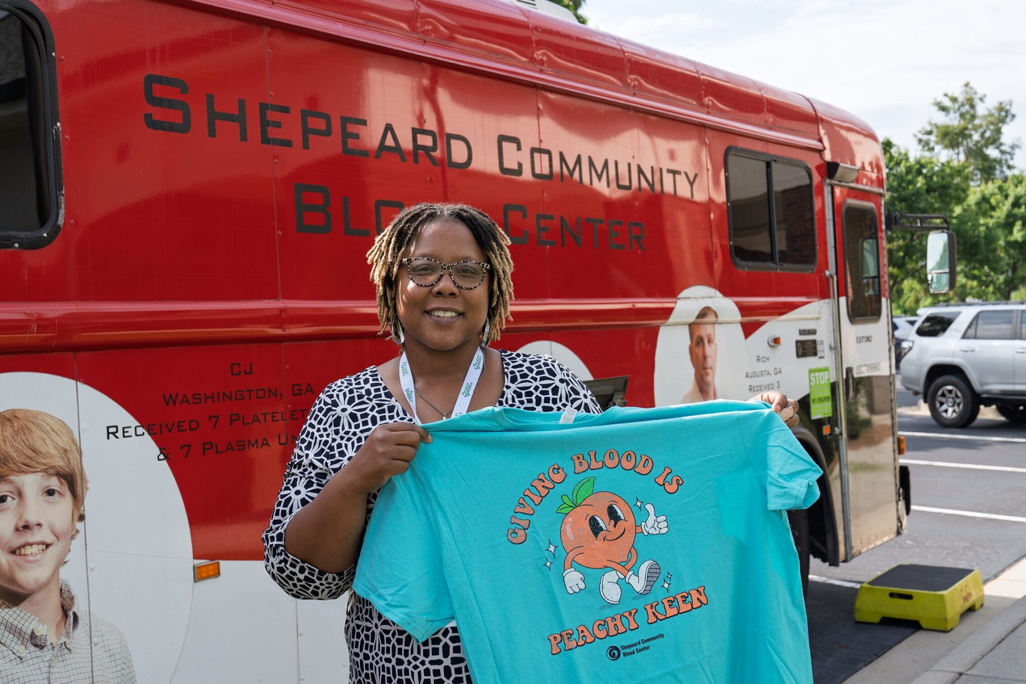 Shaquana O'Neal holds her new t-shirt from the Shepeard Community Blood Center An SRP employee holds up a t-shirt with