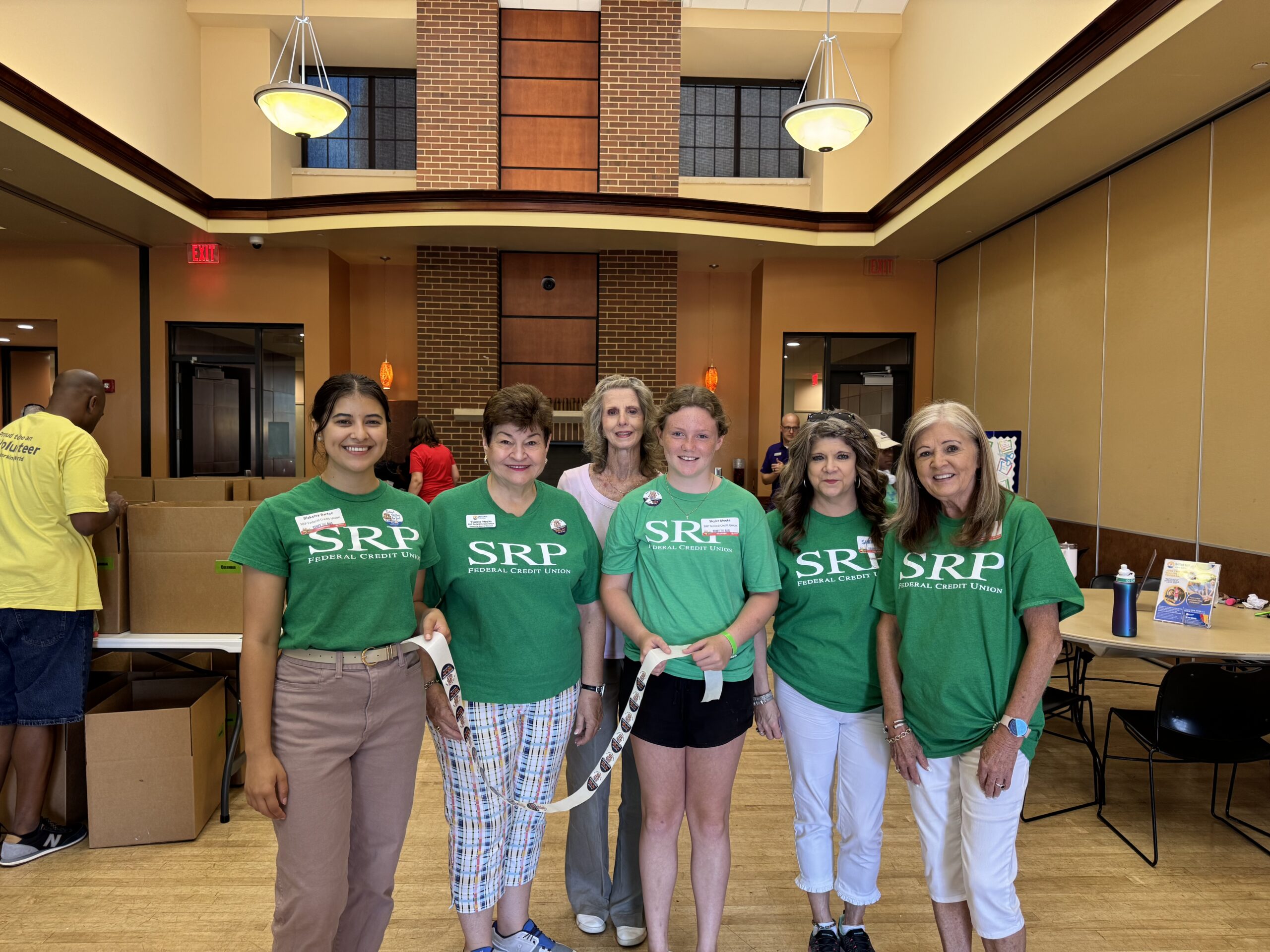 SRP team members and guests pose for a group photo inside the Salvation Army Kroc Center of Augusta, where they volunteered to sort, label, and pack school supplies for United Way's Stuff the Bus drive.