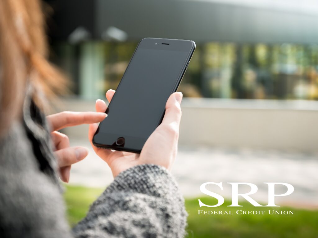 Digital payment apps A safety guide A woman holds a smart phone in an urban setting, illustrating the use of digital payment apps.