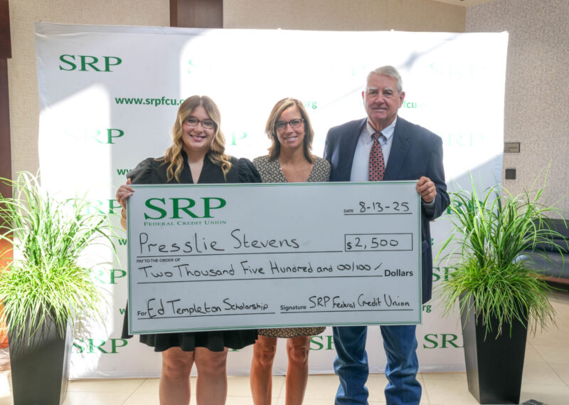 Three people pose with a ceremonial check.