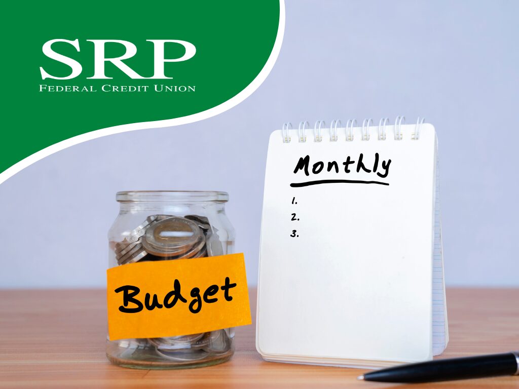 A jar full of coins next to a notepad for listing monthly expenses.