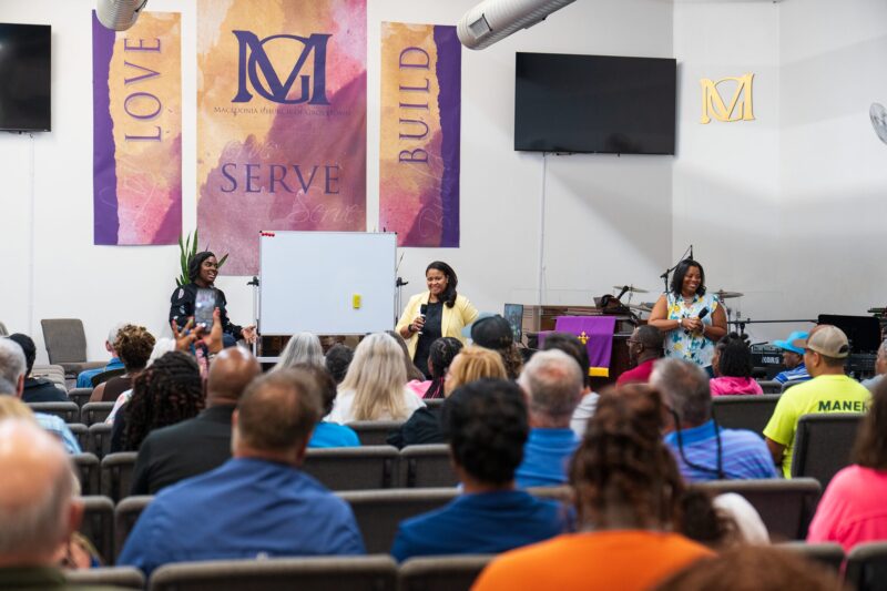 Three legal professionals speak to an audience at a local church.