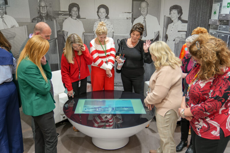 A group of people gathers around a table.