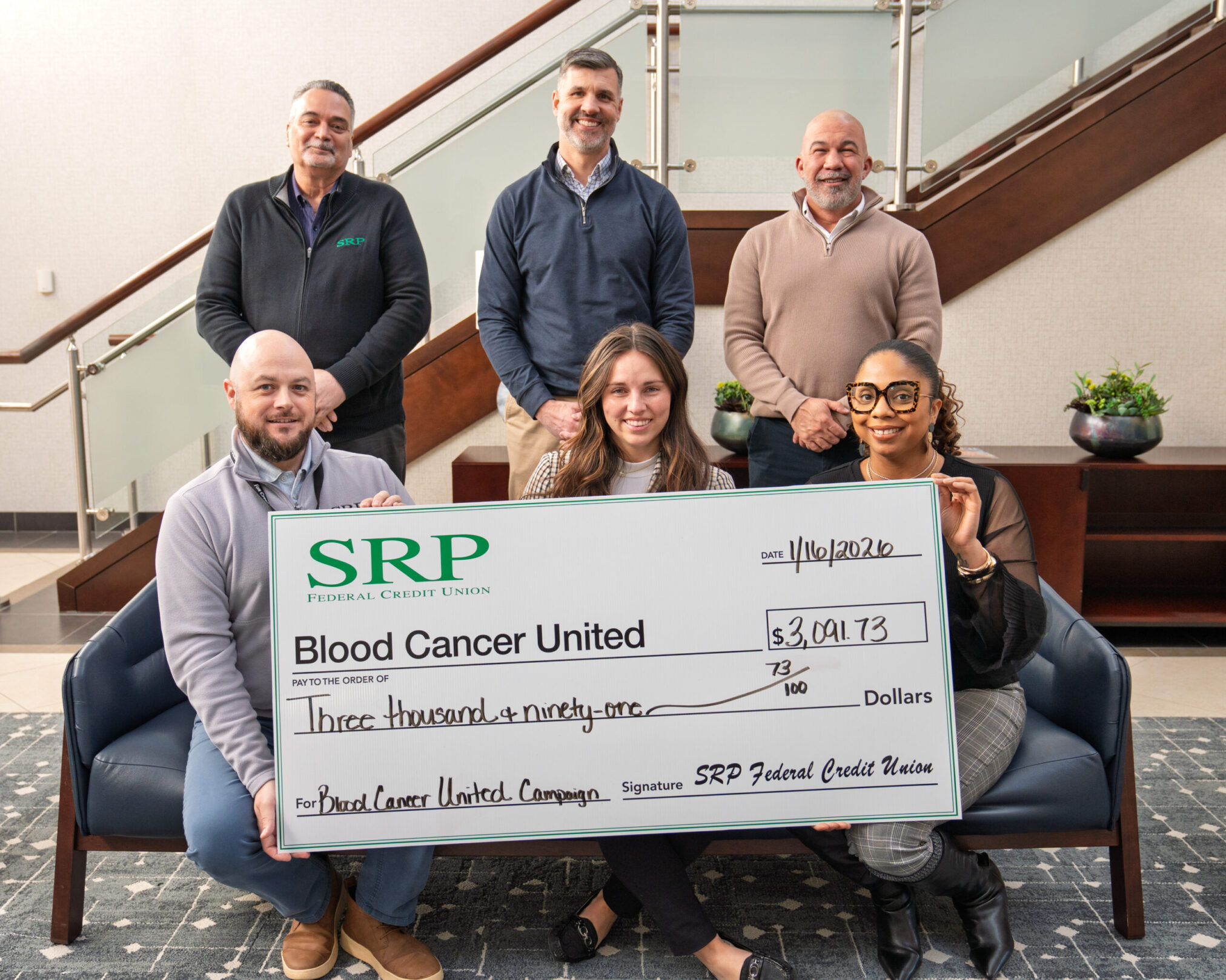 4.5ratio_Blood Cancer United Check Presentation Jan. 2026 SRP Federal Credit Union executives and ambassadors present Kaitlynn Dunmire (front row, center) with a ceremonial check for over $3,000 for Blood Cancer United.