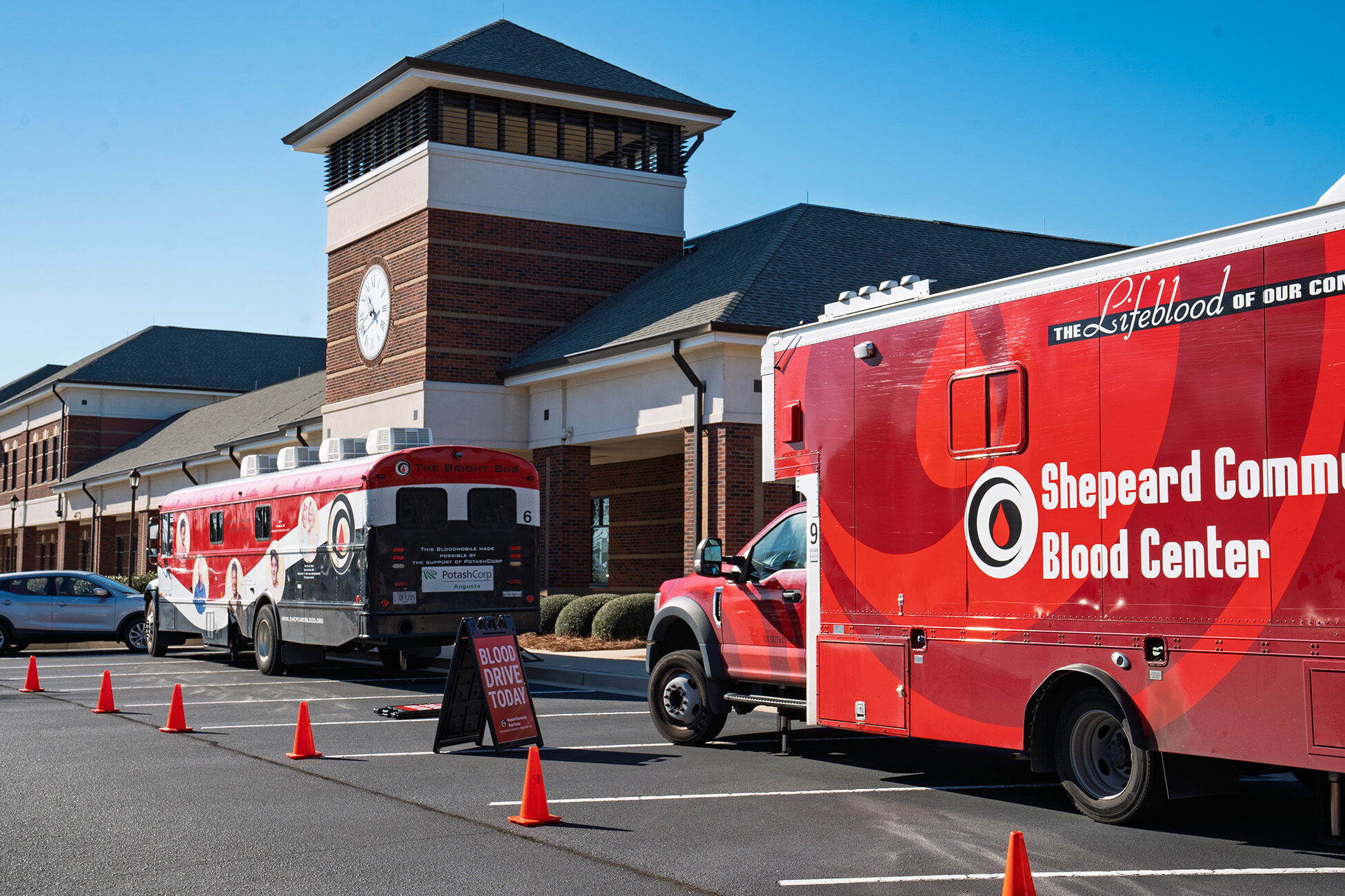 Two Shepeard Bloodmobiles parked at SRP's Administrative Campus had dozens of visitors. Two red buses in front of a building