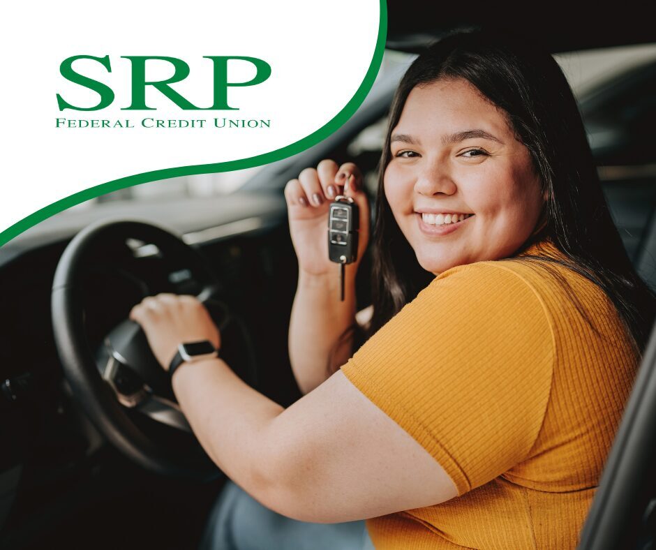 A woman in the driver's seat holds the keys to her new car.