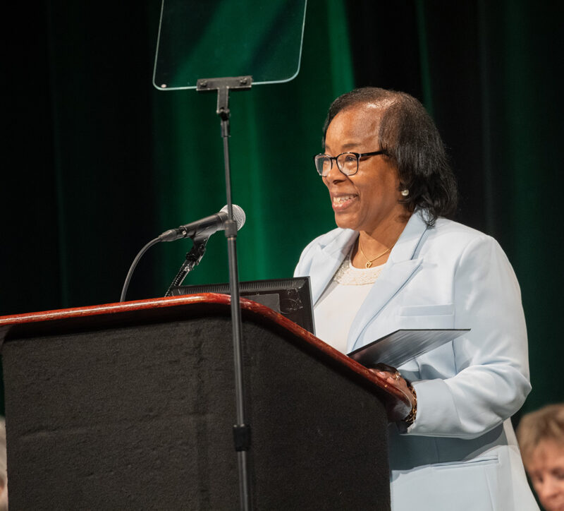 SRP Board Chairman Sandra DeVoe Bland speaks into a microphone.