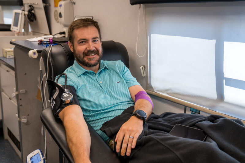 A man donates blood inside a mobile unit.