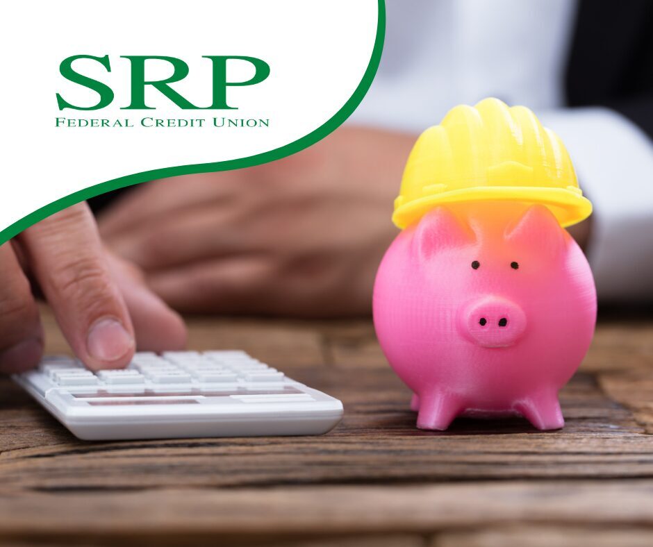 Saving More and Building An Emergency Fund A piggy bank wearing a hard hat is next to a person using a calculator, representing saving for an emergency fund.